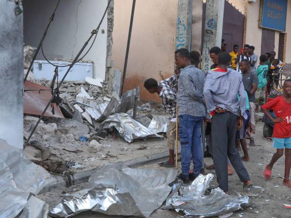 Los residentes hacen una pausa para evaluar los daños en el sitio de un ataque en el Hotel Pearl Beach en Mogadiscio el 10 de junio de 2023.