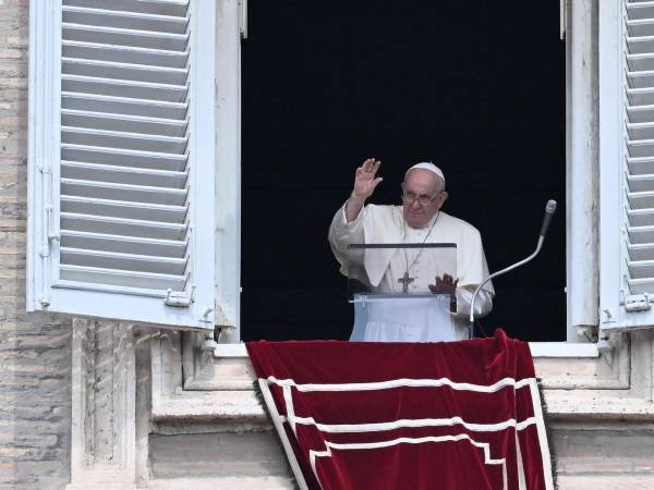 El Papa Francisco saluda a la multitud desde la ventana del palacio apostólico con vista a la plaza de San Pedro durante la oración semanal del Ángelus el 27 de agosto de 2023 en el Vaticano.