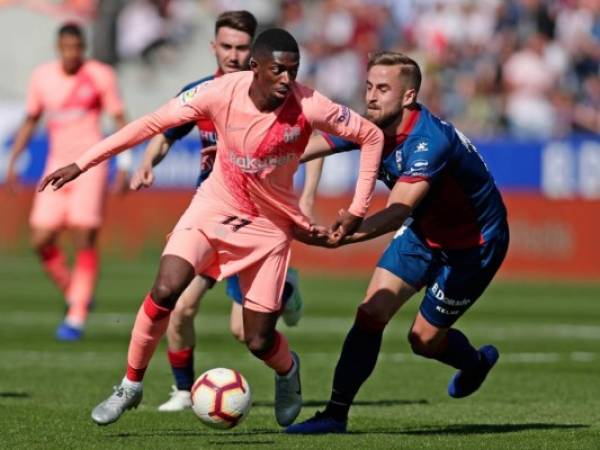 Ousmane Dembele, izquierda, lucha por el balón con Jorge Pulido de Huesca durante el partido de fútbol de la Liga española entre Huesca y Barcelona en el estadio Alcoraz de Huesca, sábado 13 de abril de 2019. (Foto AP / Manu Fernández)