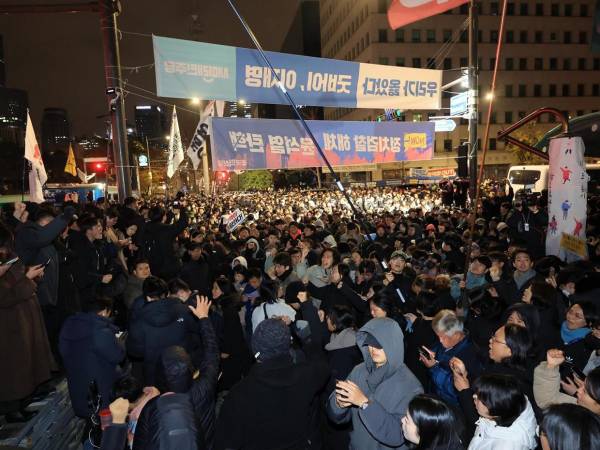 Las personas se reúnen frente a la Asamblea Nacional en Seúl, Corea del Sur, en las primeras horas del 04 de diciembre de 2024, exigiendo la retirada de la ley marcial.