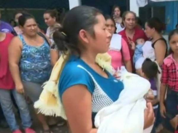 La madre de la menor de siete meses la sostiene en sus brazos antes de reingresarla al Mario Catarino Rivas.