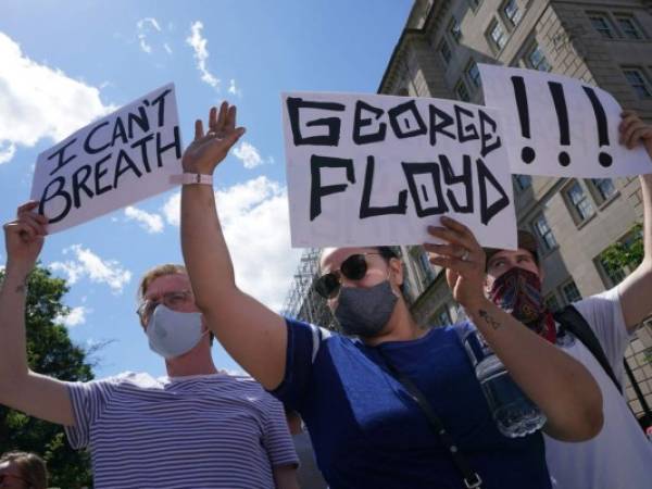 La gente que protesta por la muerte de George Floyd sostiene pancartas en Lafayette Square, junto a la Casa Blanca. Foto AFP