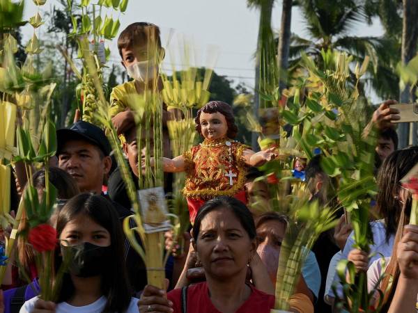 Los cristianos católicos mueven sus palmas recordando la entrada triunfal de Cristo a Jerusalén en la celebración del Domingo de Ramos que da inicio a la Semana Santa de este 2023.