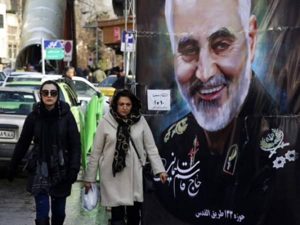 Mujeres caminan junto a un cartel del general de la Guardia Revolucionaria Qassem Soleimani, que murió en un ataque de dron estadounidense en Irak, el comandante fallecido este miércoles era un colaborador cercano. Foto: AP.