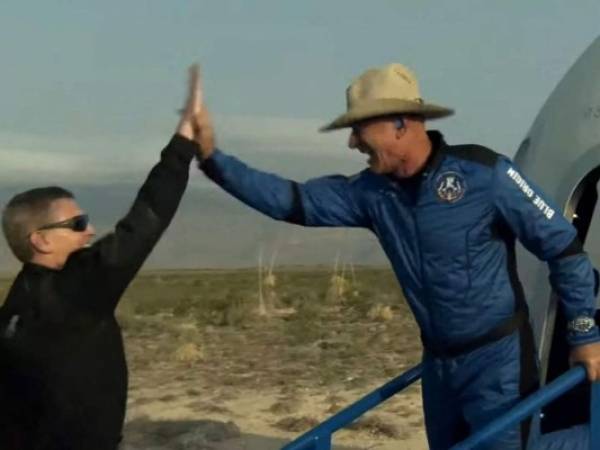 Esta imagen fija tomada del video de Blue Origin muestra a Jeff Bezos (derecha) celebrando después de salir de la cápsula reutilizable New Shepard de Blue Origin que regresó del espacio y aterrizó de manera segura el 20 de julio de 2021 en Van Horn, Texas. Foto: AFP