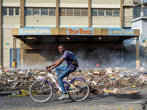 Un hombre monta una bicicleta en una carretera que quedó vacía por una huelga general en Port-au-Prince, Haití, el 28 de septiembre de 2022.