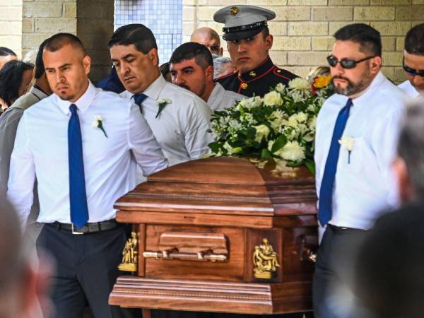 Los portadores del féretro y el infante de marina estadounidense Christian García, hijo de Linda García, llevan el ataúd de Irma Linda García y su esposo José Antonio García durante su misa fúnebre en la iglesia católica Sacred Heart en Uvalde, Texas, el 1 de junio de 2022.