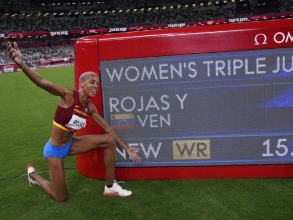 La venezolana Yulimar Rojas celebra al lado del tablero que marca el nuevo récord mundial de 15,67 que impuso al ganar la final del triple salto femenino en los Juegos Olímpicos de Verano 2020, en Tokio, el domingo 1 de agosto de 2021.