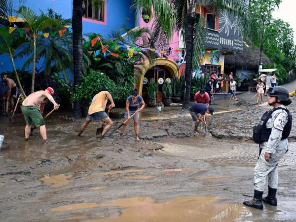 Residentes y miembros de la Guardia Nacional limpian las calles después de la llegada del huracán Roslyn a la comunidad de Sayulita, estado de Nayarit, México.