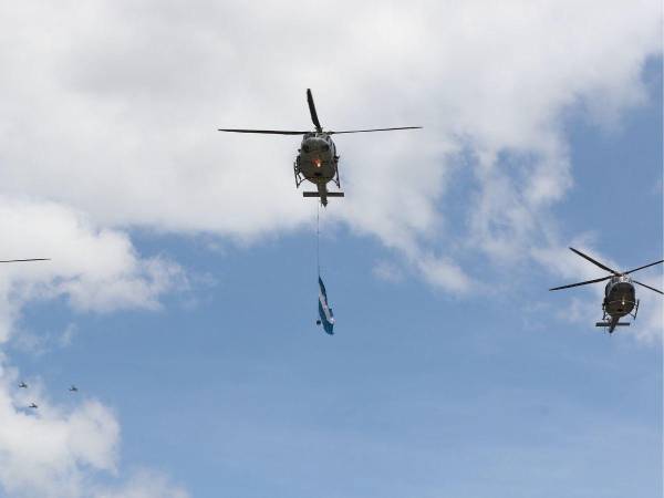 Paracaidistas de la Fuerza Aérea están preparados para aterrizar en la grama del estadio.