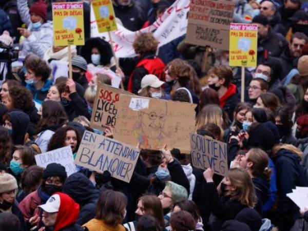 Los manifestantes sostienen carteles durante una movilización interprofesional sobre salarios y empleo en París. Foto: AFP