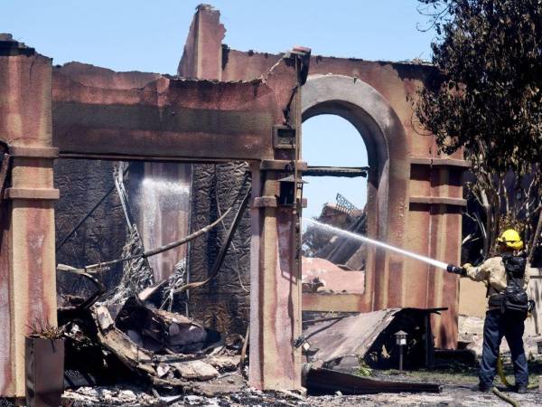 Un bombero trabaja para apagar puntos críticos en una de las más de 20 casas destruidas por el incendio costero el 12 de mayo de 2022 en Laguna Niguel, California.