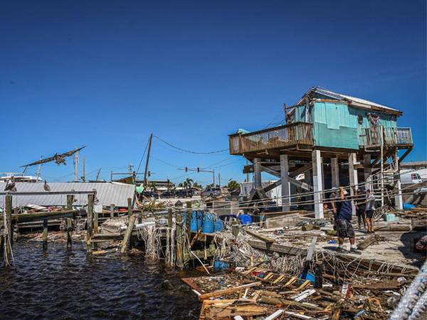 La gente limpia los escombros después del huracán Ian en Fort Myers Beach, Florida, el 30 de septiembre de 2022.