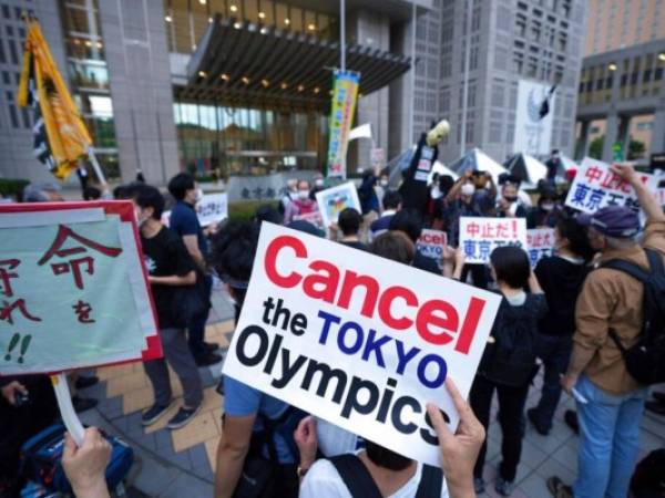 En esta imagen del 23 de junio de 2021, personas se manifiestan en contra de los Juegos Olímpicos de Tokio a las afueras de un edificio del gobierno metropolitano de Tokio. FOTO: AP