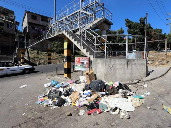 Aunque exista un rótulo advirtiendo de multas, algunos pobladores tiran su basura frente al cartel.