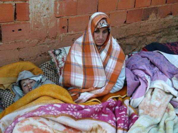 La madre y uno de los hermanos de Rayan, de 5 años, esperan mientras las autoridades y los bomberos trabajaban para sacar al niño del pozo.