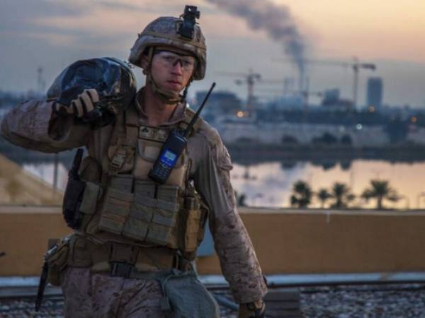 Un infante de Marina carga un saco de arena durante labores para reforzar la seguridad del complejo de la embajada estadounidense en Bagdad, Irak. Foto: AP.