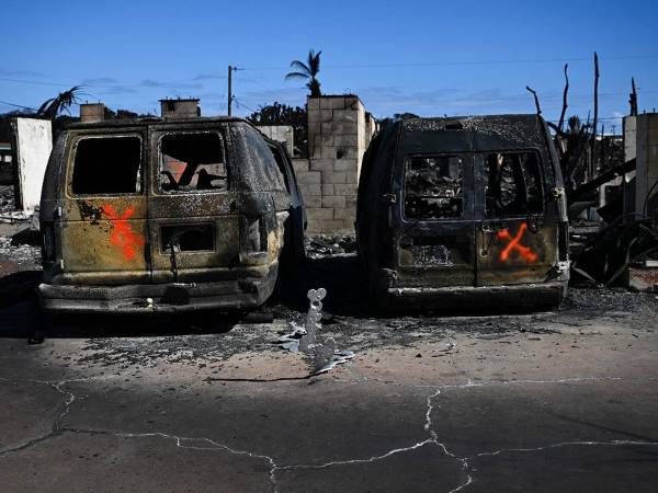 Los marcadores de pintura en aerosol de un equipo de búsqueda y rescate indican el estado de búsqueda de vehículos después de un incendio forestal en Lahaina, en el oeste de Maui.