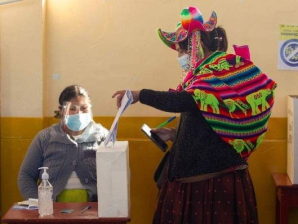 Una mujer indígena quechua vestida con atuendo típico étnico emite su voto en un colegio electoral en la remota aldea rural de Capachica, en Puno, Perú, cerca de la frontera con Bolivia. Foto: AFP