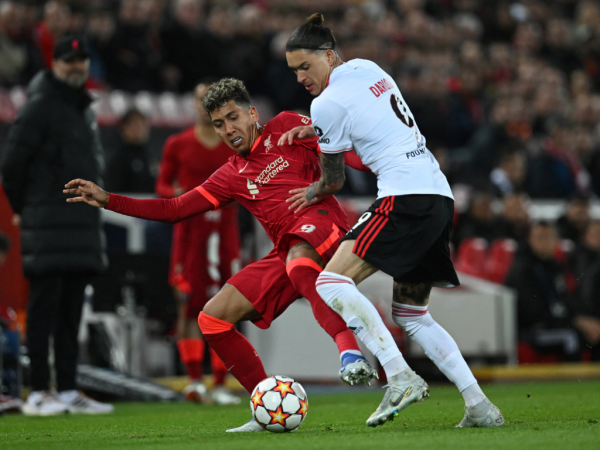 El centrocampista brasileño del Liverpool Roberto Firmino (izq.) lucha por el balón con el delantero uruguayo del Benfica Darwin Núñez durante el partido de fútbol de vuelta de los cuartos de final de la UEFA Champions League entre el Liverpool y el Benfica en el estadio de Anfield.