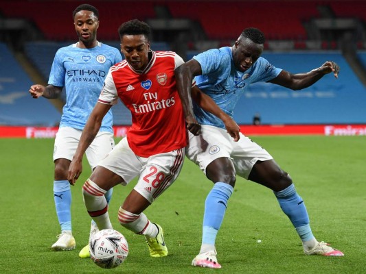 El mediocampista inglés del Arsenal Joe Willock (C) se enreda con el defensor francés del Manchester City Benjamin Mendy (R) durante la semifinal de la Copa FA inglesa de fútbol entre el Arsenal y el Manchester City en el estadio de Wembley en Londres. Foto: Agencia AFP.