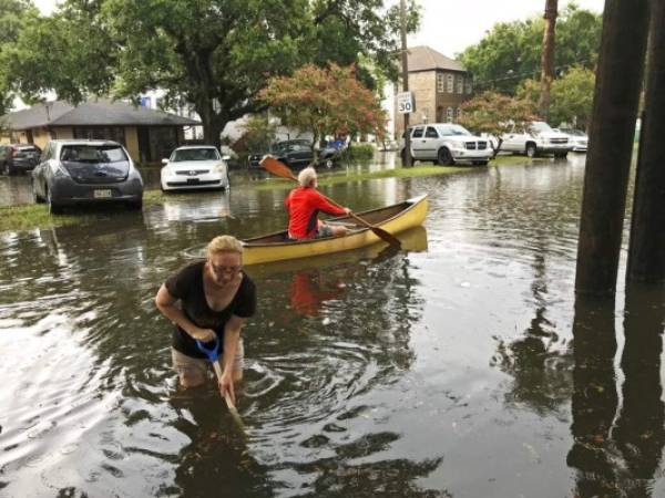 Personas realizan trabajos de limpieza después de una intensa tormenta en el vecindario Broadmoor de Nueva Orleans. Foto: AP.