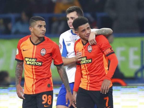 El brasileño Taison del club Shakhtar, llora mientras abandona la cancha tras ser expulsado por reaccionar a los insultos racistas de aficionados, mientras es acompañado por su compañero y compatriota Dodó y Mykola Shaparenko. Foto: AP.