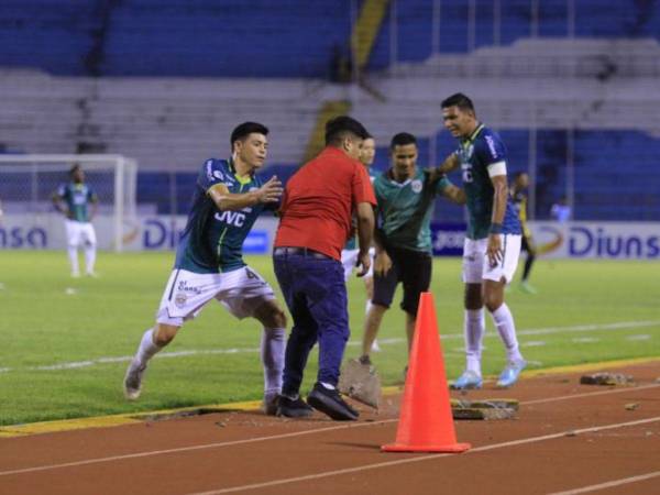 Jugadores del Marthón intentan detener a algunos aficionados que ingresaron al campo de juego.