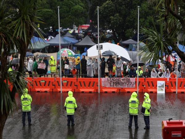 La policía se para bajo la lluvia mientras protege el Parlamento en el quinto día de manifestaciones contra las restricciones de Covid-19 en Wellington el 12 de febrero de 2022, inspirado en una manifestación similar en Canadá.