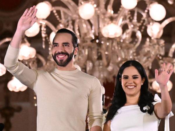 El presidente salvadoreño Nayib Bukele saluda a sus partidarios junto a su esposa Gabriela Rodríguez después de las elecciones presidenciales y legislativas en San Salvador el 4 de febrero de 2024.