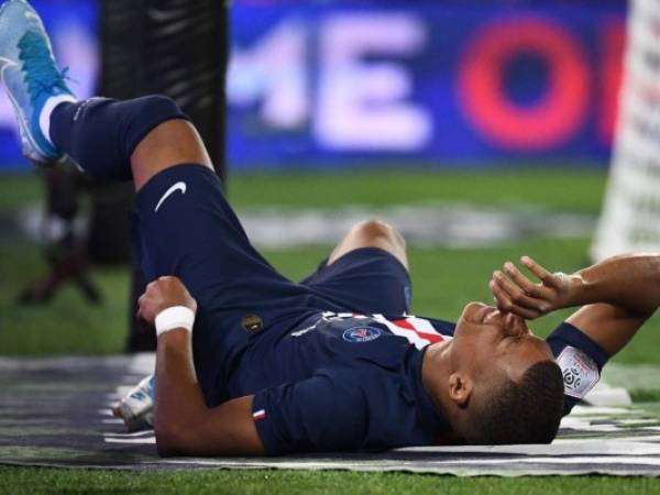 El delantero francés de Paris Saint-Germain, Kylian Mbappe, reacciona después de una lesión durante el partido de fútbol francés L1 entrePGS y Toulouse en el estadio Parc des Princes de París. Foto: AFP.