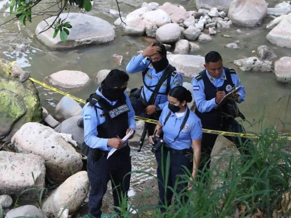 Agentes de la Dirección Policial de Investigaciones (DPI) en una escena del crimen en el Distrito Central.