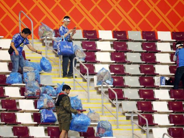 Con bolsas plásticas fueron captadas los aficionados de Japón, que se quedaron limpiando el estadio Internacional Jalifa.