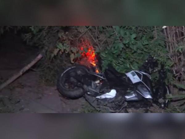 La motocicleta quedó en una pequeña hondonada al lado de la carretera.