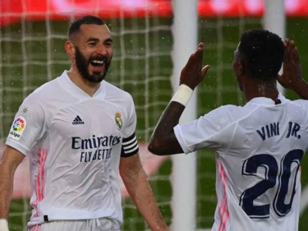 El delantero francés del Real Madrid Karim Benzema, celebra con el delantero brasileño Vinicius Junior, tras marcar un gol durante el partido de fútbol en el estadio Alfredo di Stefano de Valdebebas. FOTO: AFP