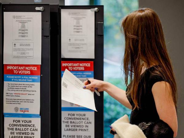 Mujer escanea su papeleta en el centro de votación de la biblioteca Ponce de León ubicado en el condado de Fulton en Atlanta, Georgia.