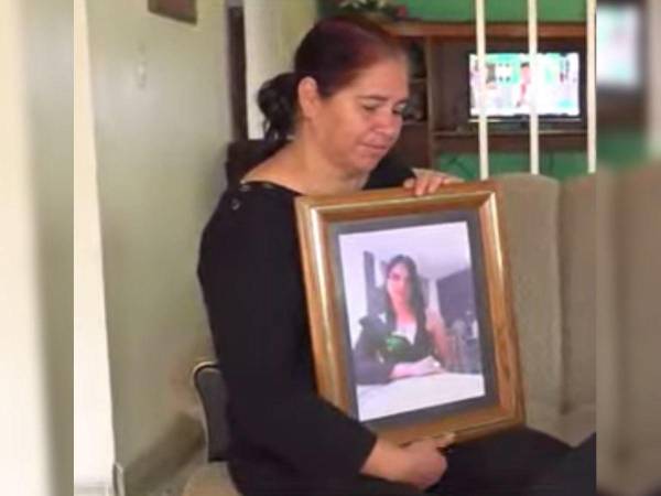 Suyapa Cantillano sostiene en su manos un cuadro con la fotografía de su hija muerta.