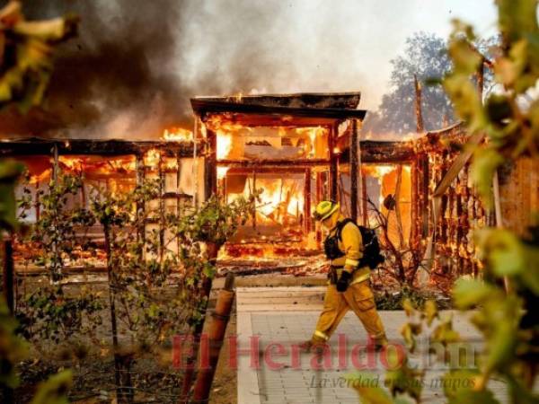 El bombero Joe Zurilgen camina frente a una casa envuelta en llamas en Healdsburg, California, el domingo 27 de octubre de 2019. AP Foto/Noah Berger