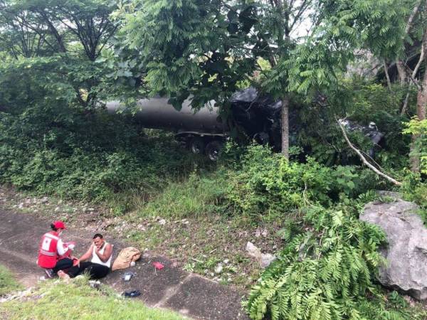 Al salirse de la carretera, la rastra quedó incrustrada entre dos árboles.