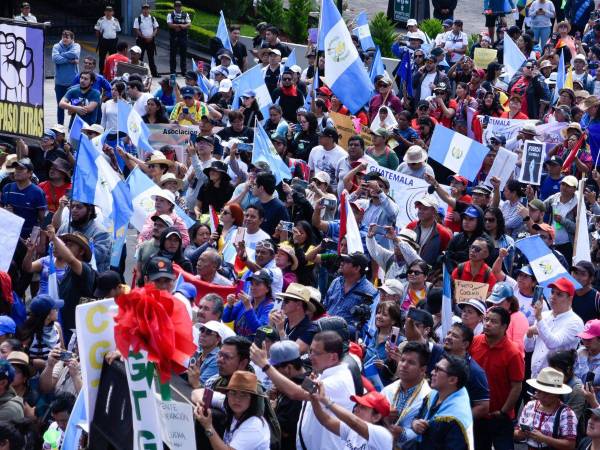 La gente participa en una manifestación para conmemorar el 79º aniversario de la Revolución que derrocó al dictador Jorge Ubico en 1944 y para exigir la renuncia de la Fiscal General Consuelo Porras y del Fiscal Rafael Curruchiche en la Ciudad de Guatemala el 20 de octubre de 2023.