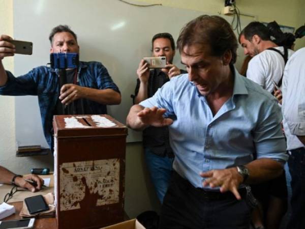 El candidato presidencial para el partido del Partido Nacional de Uruguay, Luis Lacalle, hace un gesto al emitir su voto en un colegio electoral en Canelones, departamento de Canelones, durante la segunda vuelta de las elecciones.