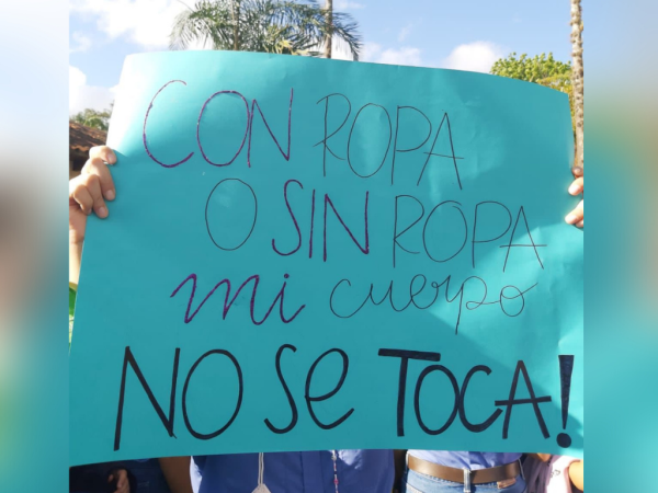 Una estudiante de la Escuela Agrícola Panamericana sostiene un cartel en protesta por la presunta violación de sus compañeras de institución.