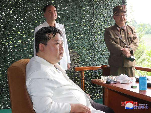 Kim Jong Un luce distraído mientras al fondo se observa el teléfono celular.