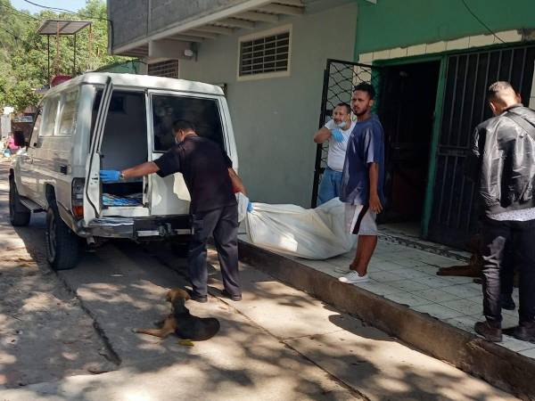 El personal forense mientras realizaba el levantamiento de un cuerpo para su posterior autopsia.