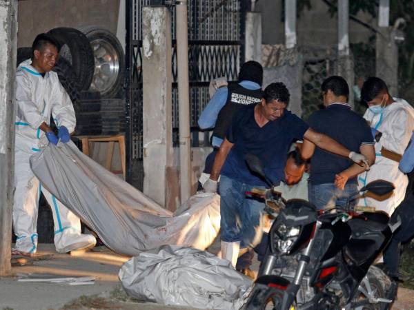 Personal forense retira los cuerpos de once personas muertas en un salón de billar en Choloma, a unos 180 km al norte de Tegucigalpa, el 25 de junio de 2023.