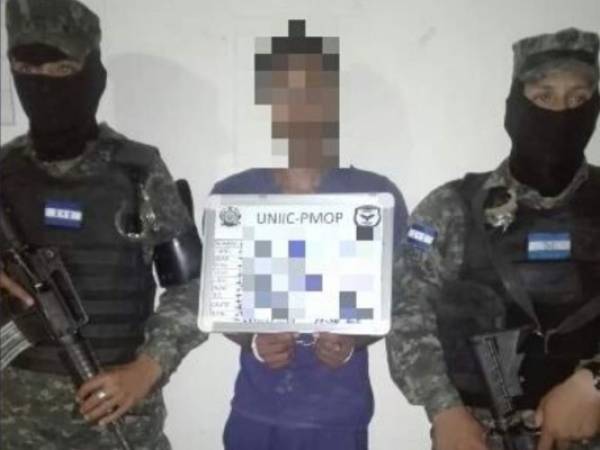 El detenido Donald Nahún Padilla Montes posa junto a dos elementos de la Policía Militar del Orden Público (PMOP).