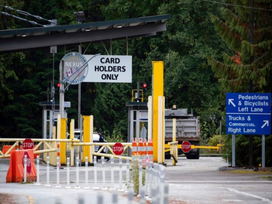 Un agente de la Oficina de Aduanas y Protección Fronteriza de Estados Unidos que labora en el cruce fronterizo Point Roberts-Boundary Bay en Point Roberts, Washington, es visto el miércoles 13 de octubre de 2021 desde Delta, Columbia Británica. (Darryl Dyck/The Canadian Press vía AP).