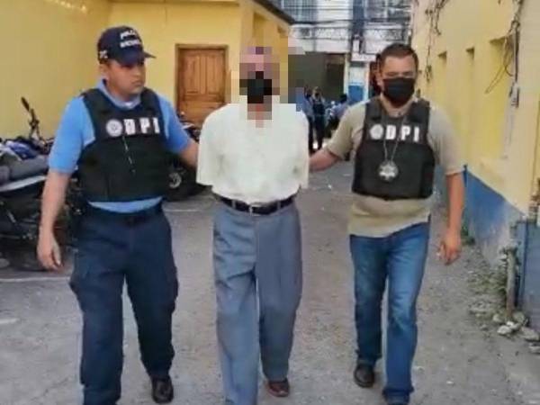 Agentes policiales custodian al supuesto estafador.