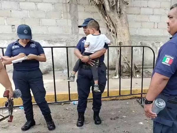 Una agente municipal sostenía al pequeño Caleb, mientras sus compañeros intentaban gestionar la búsqueda de sus padres o tutores.