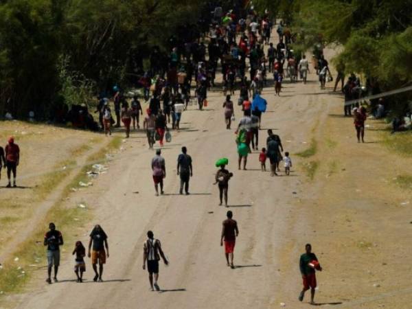 Migrantes haitianos caminan por un camino de tierra después de ingresar a Estados Unidos desde México, el viernes 17 de septiembre de 2021, en Del Rio, Texas. Foto: AP